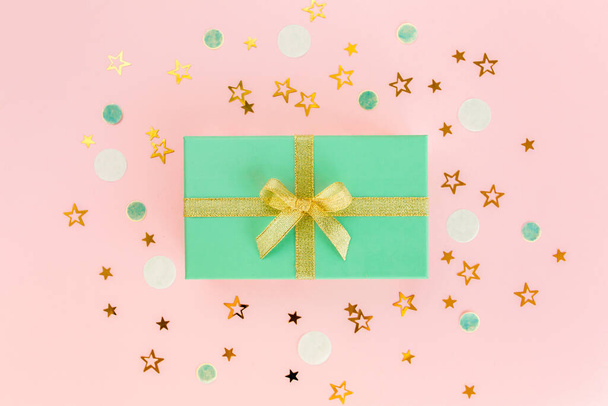 Gift or present box and stars confetti on a pink background. Colorful celebration, birthday. Christmas or New Year pattern. Flat lay, top view  - Fotoğraf, Görsel