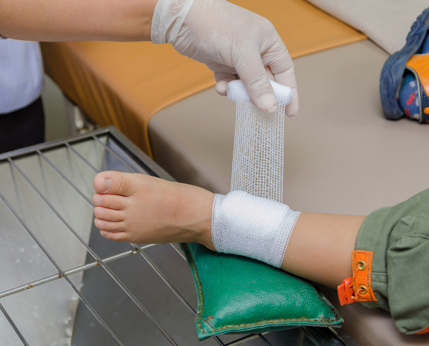 child boy with bandage on leg and lying down hospital bed - Photo, Image