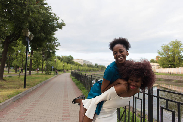 de gelukkige Afro-Amerikaanse vrouwen knuffelen, vrienden - Foto, afbeelding