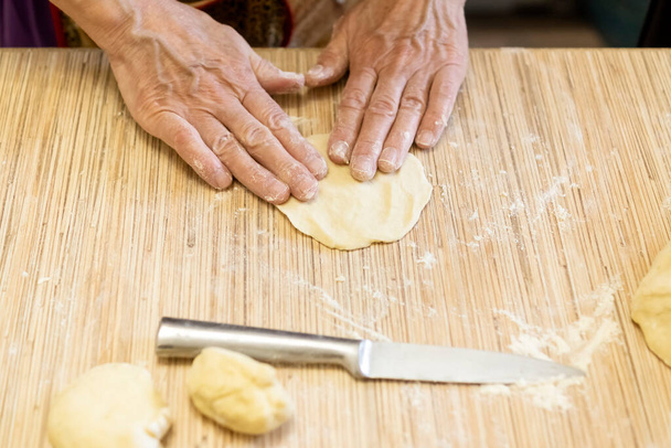Hands of woman preparing dough pies to bake - Photo, Image