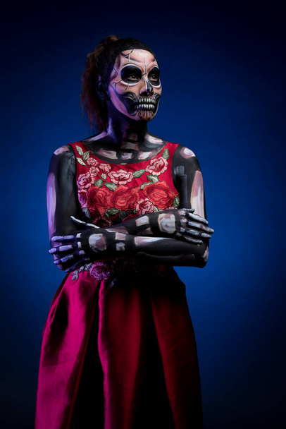 Cráneo con vestido rojo y fondo azul - Foto, Imagen