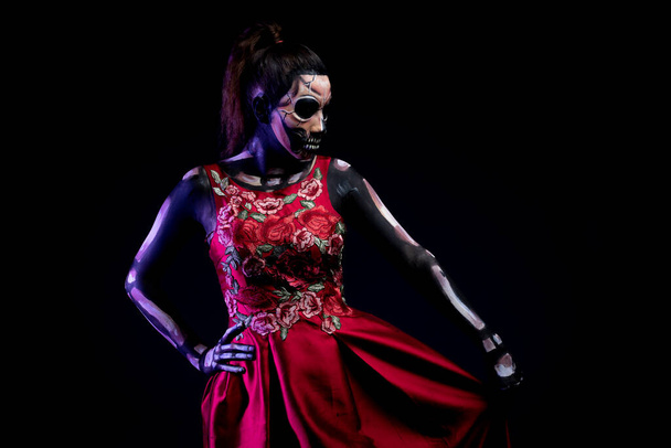 Calavera mujer personificada con vestido rojo y fondo negro - Foto, imagen