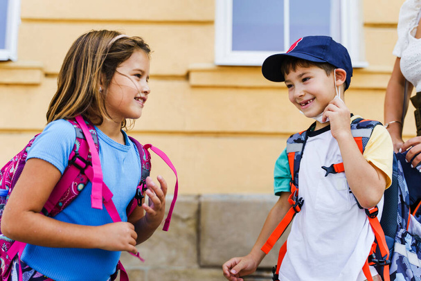 Портрет маленького кавказького хлопчика і дівчинки-брата і сестри або маленьких друзів Діти йдуть до школи першого класу зі школярами з рюкзаками на спині в сонячний день відкритий копіювальний простір
 - Фото, зображення
