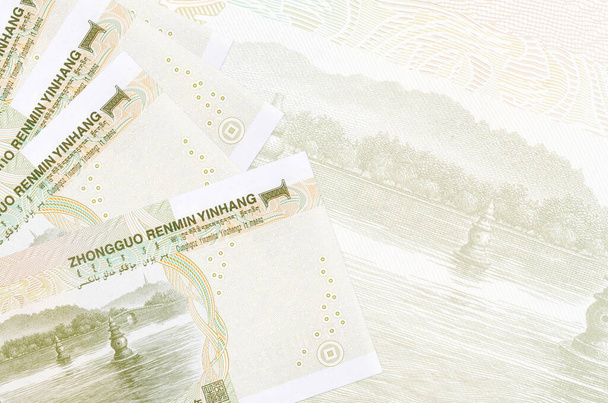 1 Chinese yuan biljetten ligt in stapel op de achtergrond van grote semi-transparante bankbiljet. Abstract zakelijke achtergrond met kopieerruimte - Foto, afbeelding