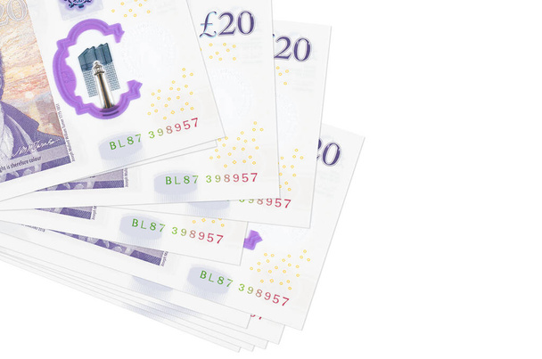 20 Britse pond biljetten liggen in kleine troep of roedel geïsoleerd op wit. Mockup met kopieerruimte. Bedrijfs- en wisselkoersconcept - Foto, afbeelding