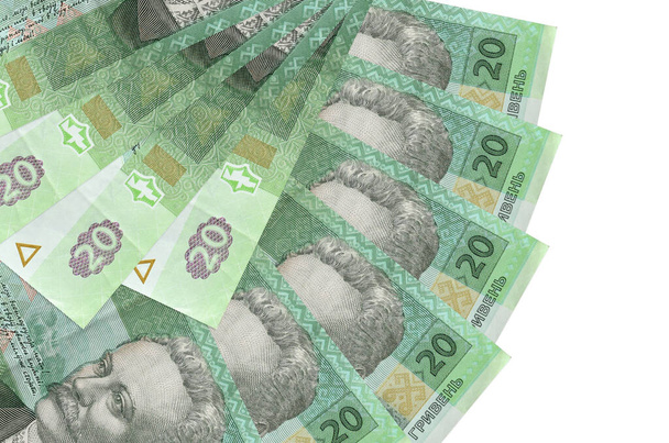 20 Oekraïense hryvnias biljetten ligt geïsoleerd op witte achtergrond met kopieerruimte gestapeld in ventilatorvorm close-up. Begrip financiële transacties - Foto, afbeelding