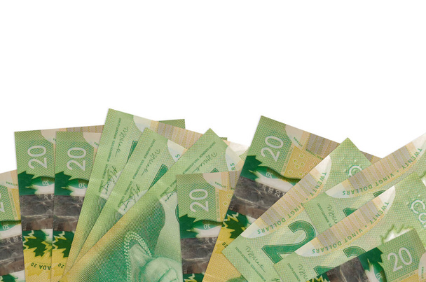 20 Канадські доларові купюри лежать на нижній стороні екрану, ізольованого на білому тлі з копіювальним простором. Фоновий прапор шаблон для бізнес концепції з грошима - Фото, зображення
