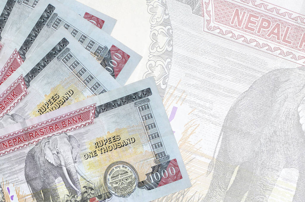 1000 banconote da 1000 rupie nepalesi giacciono in pila sullo sfondo di una grande banconota semi-trasparente. Astratto sfondo aziendale con spazio di copia - Foto, immagini