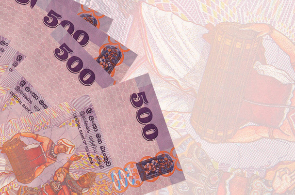 500 billetes de rupias de Sri Lanka se encuentra en la pila en el fondo de un gran billete semitransparente. Fondo de negocio abstracto con espacio de copia - Foto, Imagen