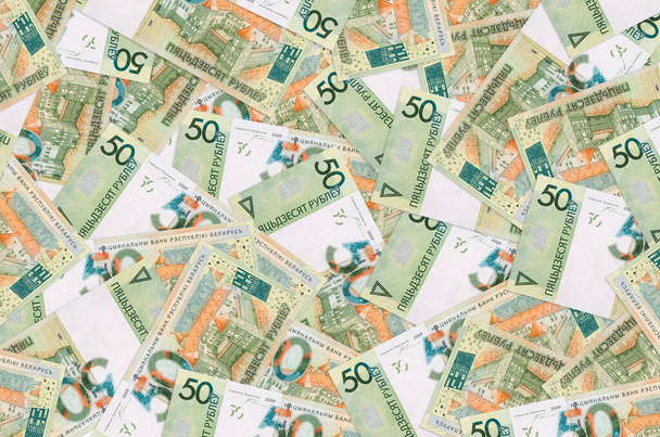 50 rubel białoruski banknot leżę w duży kupka. Bogata konceptualna przeszłość życia. Duża suma pieniędzy - Zdjęcie, obraz