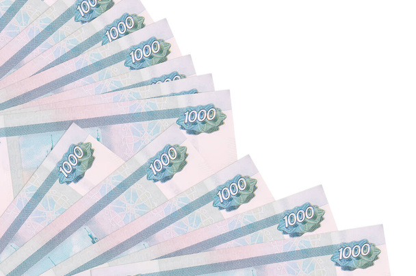 1000 ρώσικα ρούβλια βρίσκονται απομονωμένα σε λευκό φόντο με χώρο αντιγραφής στοιβαγμένο στον ανεμιστήρα από κοντά. Έννοια του χρόνου πληρωμής ή χρηματοοικονομικές πράξεις - Φωτογραφία, εικόνα