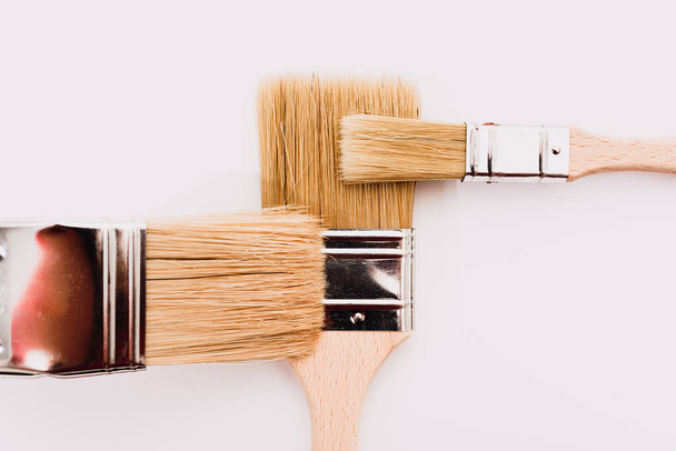 White background with painter brushes for decoration business and home renovations. - Фото, зображення
