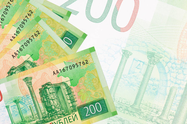 Na pozadí velké poloprůhledné bankovky leží 200 ruských rublů bankovek. Abstraktní obchodní pozadí s kopírovacím prostorem - Fotografie, Obrázek