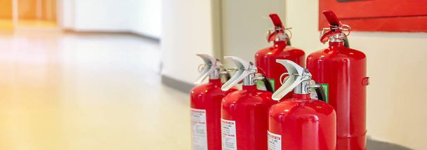 Réservoir d'extincteurs rouges à la porte de sortie dans les concepts de construction de la sécurité d'urgence pour la prévention des incendies sauvetage et les services d'incendie concietps. - Photo, image
