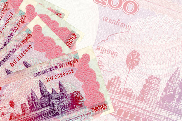 500 billetes de rieles camboyanos se encuentran en la pila en el fondo de un gran billete semitransparente. Fondo de negocio abstracto con espacio de copia - Foto, imagen