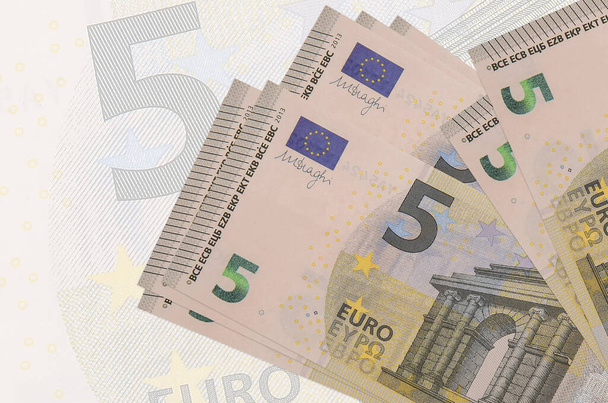 5 eurobiljetten liggen in stapel op de achtergrond van groot semi-transparant bankbiljet. Abstracte presentatie van de nationale munt. Bedrijfsconcept - Foto, afbeelding