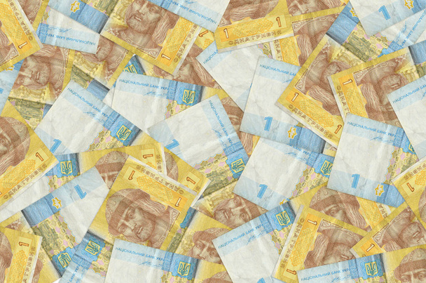 1 Ukrainian hryvnia bills lies in big pile. Rich life conceptual background. Big amount of money - Φωτογραφία, εικόνα