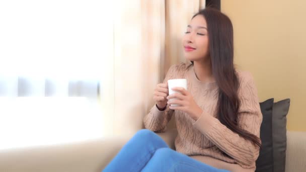 filmati di bella donna asiatica bere il tè a casa durante la quarantena - Filmati, video