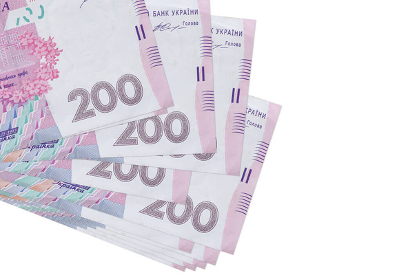 200 billetes de hryvnias ucranianas se encuentra en un pequeño manojo o paquete aislado en blanco. Mockup con espacio de copia. Concepto de negocio y cambio de divisas - Foto, Imagen