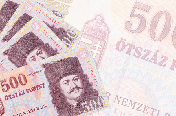 500 Hongaarse forint biljetten liggen in stapel op de achtergrond van een groot semi-transparant bankbiljet. Abstract zakelijke achtergrond met kopieerruimte - Foto, afbeelding