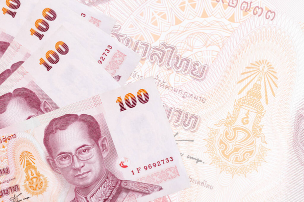 100 billetes de Baht tailandés se encuentra en la pila en el fondo de gran billete semitransparente. Fondo de negocio abstracto con espacio de copia - Foto, imagen