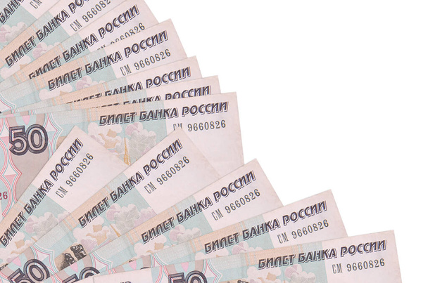 50 Russische roebel biljetten ligt geïsoleerd op witte achtergrond met kopieerruimte gestapeld in ventilator close-up. Begrip "betaaldag" of financiële transacties - Foto, afbeelding
