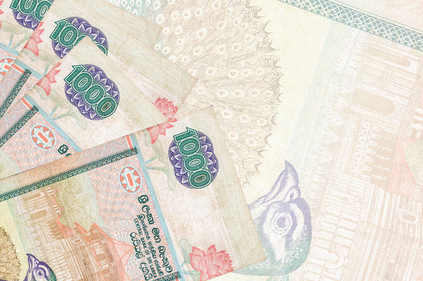 1000 billetes de rupias de Sri Lanka se encuentra en la pila en el fondo de gran billete semitransparente. Fondo de negocio abstracto con espacio de copia - Foto, Imagen