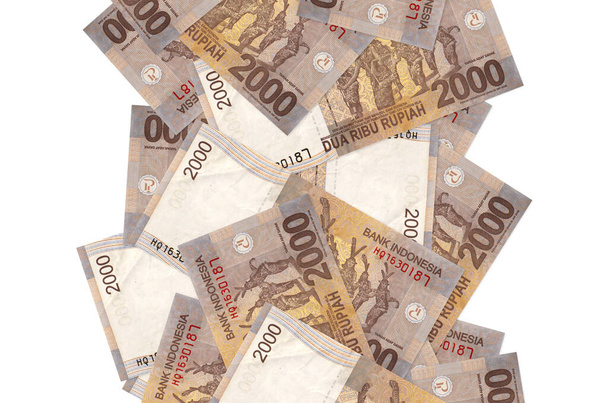 2000 indonéz rúpiás bankjegy repül le, elszigetelve a fehéren. Sok bankjegy esik fehér fénymásolási hellyel a bal és a jobb oldalon - Fotó, kép