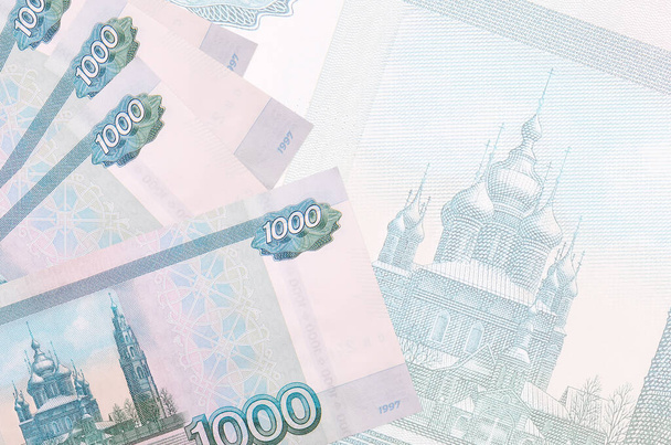 1000 rosyjskich rubli leży w stosach na tle dużego półprzezroczystego banknotu. Streszczenie kontekstu biznesowego z przestrzenią do kopiowania - Zdjęcie, obraz