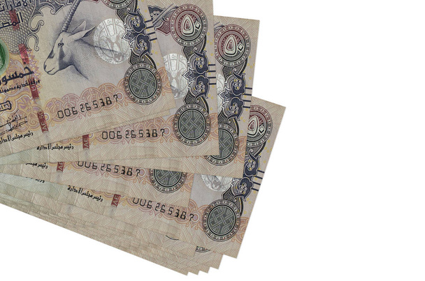 50 банкнот дирхамов ОАЭ лежат в небольшом пакете или упаковке, изолированной на белом. Макет с копировальным пространством. Концепция бизнеса и обмена валюты - Фото, изображение