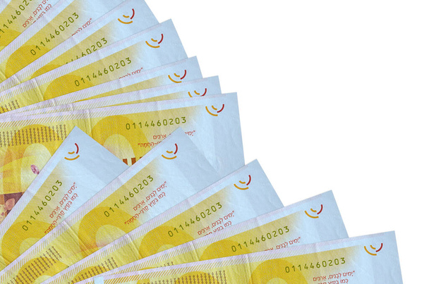 100 Israelin uutta sekeliä seteleitä on eristetty valkoisella pohjalla, ja kopiotila on pinottu tuulettimeen läheltä. Maksupäivän käsite tai rahoitustoimet - Valokuva, kuva