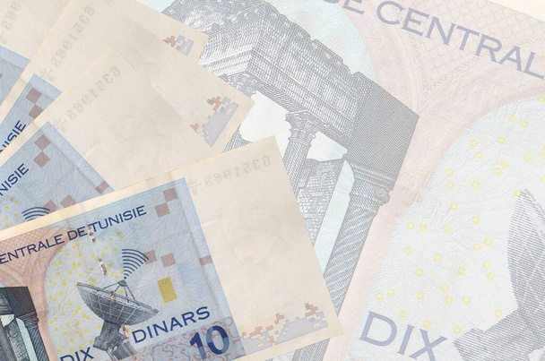 10 billetes de dinares tunecinos se encuentra en la pila en el fondo de gran billete semitransparente. Fondo de negocio abstracto con espacio de copia - Foto, imagen