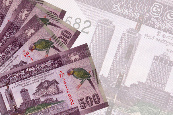 500 Sri Lankaanse roepies biljetten liggen in stapel op de achtergrond van grote semi-transparante bankbiljet. Abstract zakelijke achtergrond met kopieerruimte - Foto, afbeelding