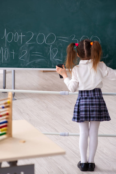 Μικρό κορίτσι μπροστά από μαυροπίνακα στην τάξη - Φωτογραφία, εικόνα