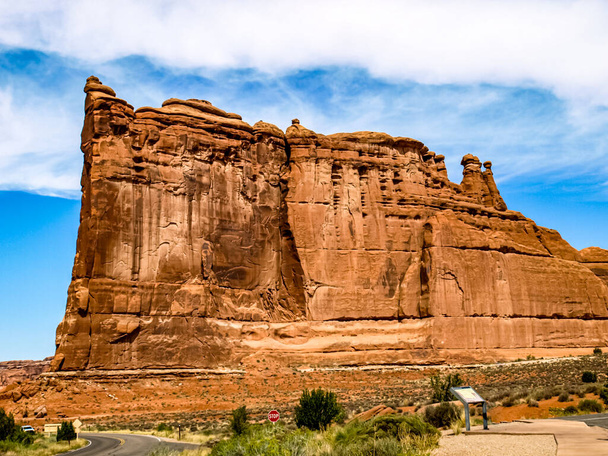 Riesige rote Felswand, mindestens 250 Mal so groß wie ein durchschnittlicher Mensch, Arches National Park, UT, USA - Foto, Bild
