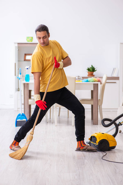 Young male contractor cleaning the house - Foto, immagini