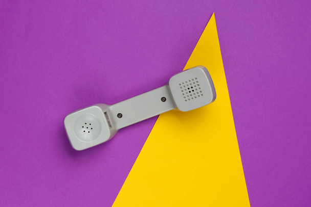 Drie Retro telefoon handset op gekleurde papieren achtergrond met geometrische vormen. Popcultuur. 80-er jaren. Minimalistisch modebeeld. Bovenaanzicht - Foto, afbeelding