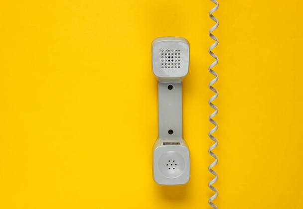 Reto handset telefoon met kabel op gele achtergrond. Bel het centrum. Hotline. Bovenaanzicht - Foto, afbeelding