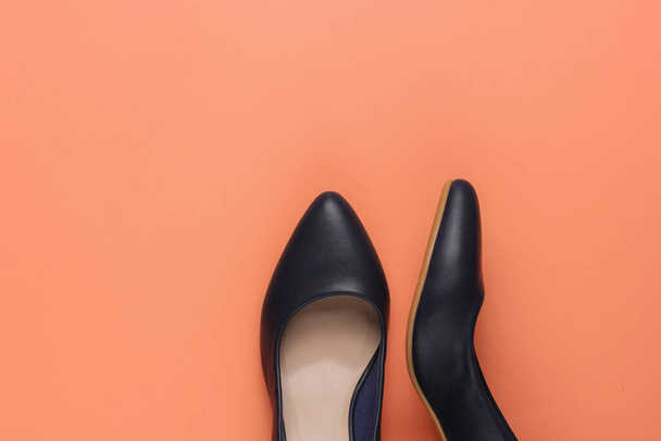 Zapatos clásicos de tacón alto para mujer sobre fondo de papel coral. Zapatos elegantes. Moda minimalista naturaleza muerta. - Foto, imagen