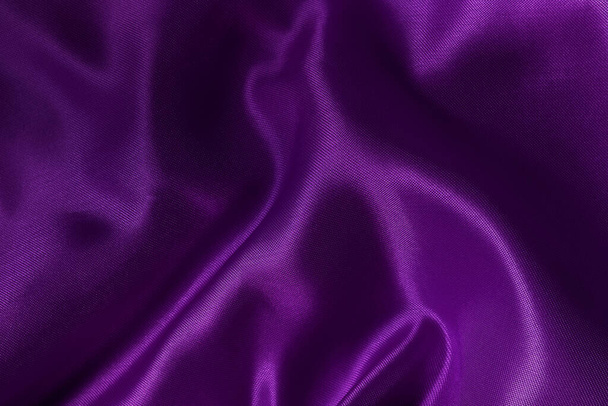 背景やデザインアート作品のための紫色の布のテクスチャ、シルクやリネンの美しいしわのパターン. - 写真・画像