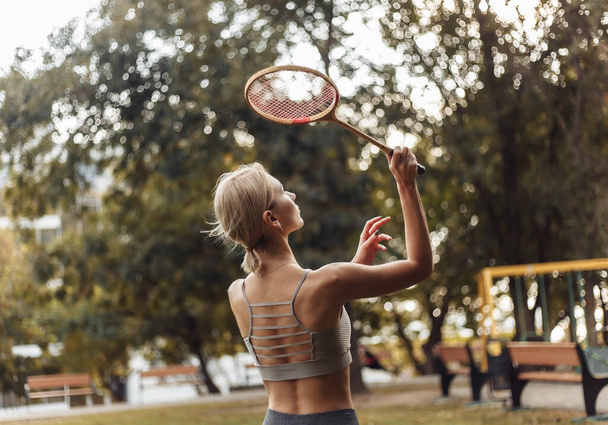 Młoda atrakcyjna kobieta sport gra badminton w parku w jasny słoneczny dzień - Zdjęcie, obraz