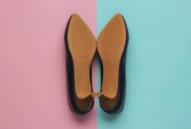 the sole of leather women's shoes with heels on blue-pink pastel background. Minimalistic fashion. Top view - Foto, Imagen