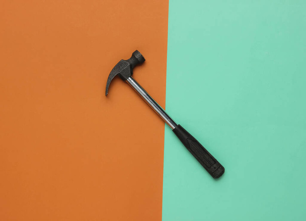 Hammer on brown blue background. Top view, minimalism - Zdjęcie, obraz