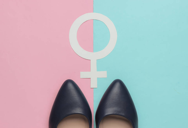 Feminisme. Vrouwelijk gendersymbool, hoge hak schoenen op roze blauwe pastel achtergrond. Bovenaanzicht - Foto, afbeelding
