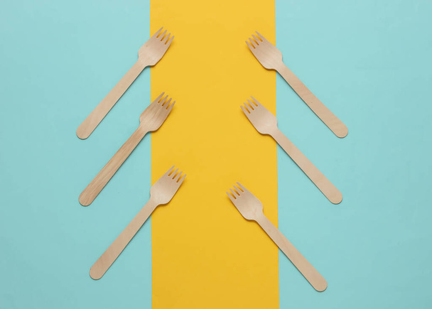 Tenedores de madera sobre un fondo de papel de color. Vista superior - Foto, Imagen