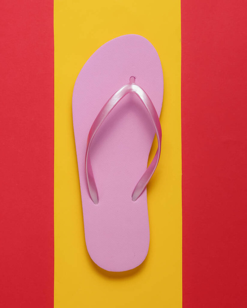 Pink flip flops on a yellow-red background. Top view. Minimalism. - Photo, Image