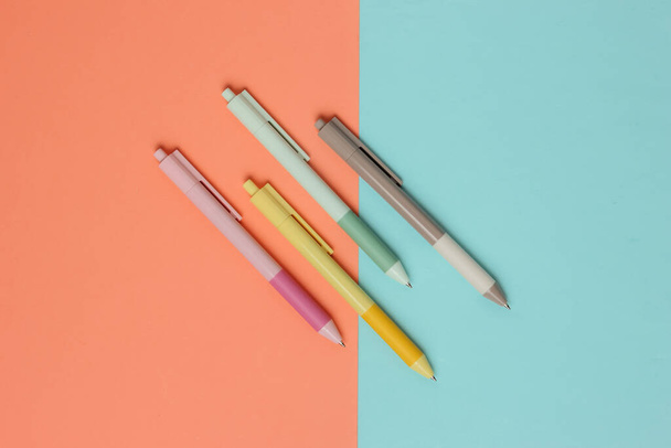Egy csomó színes tollak közelkép rózsaszín kék háttér. - Fotó, kép
