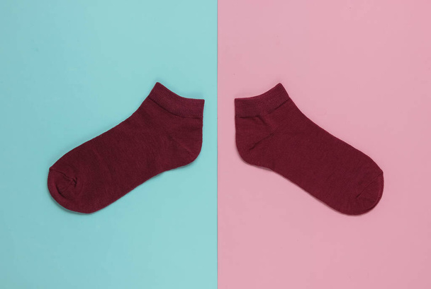 Red socks on pink blue background. Pastel color trend. Top view - Photo, Image
