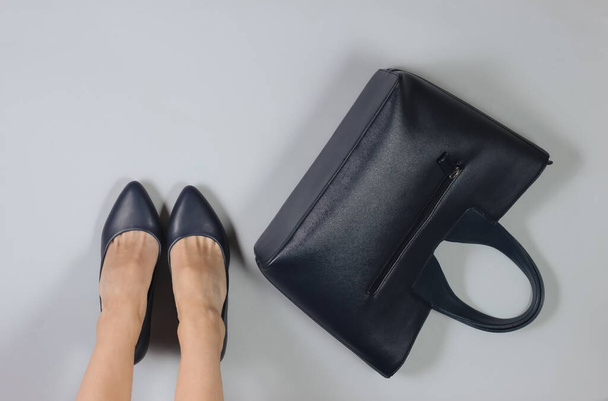Slim gambe femminili di donna d'affari con scarpe classiche, borsa in pelle. Studio moda girato su sfondo bianco. Vista dall'alto - Foto, immagini