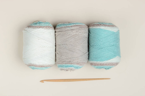 Espetos de lã de fio e gancho de crochê em um fundo bege. Vista superior - Foto, Imagem